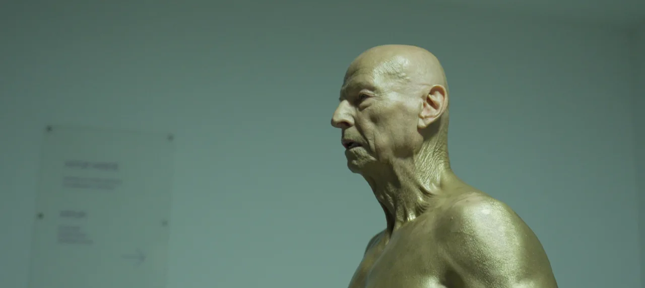 Filmový záběr na Boba Divílka hledícího z okna svého domova ve Zlíně.