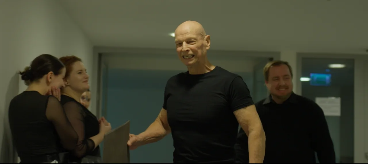 Režisér a Bob Divílek společně sledují čerstvě natočený záběr na náhledovém monitoru.