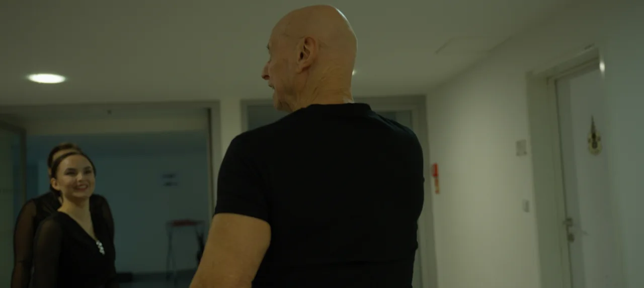 Štáb při práci na profesionálním osvětlení scény v tělocvičně během natáčení.