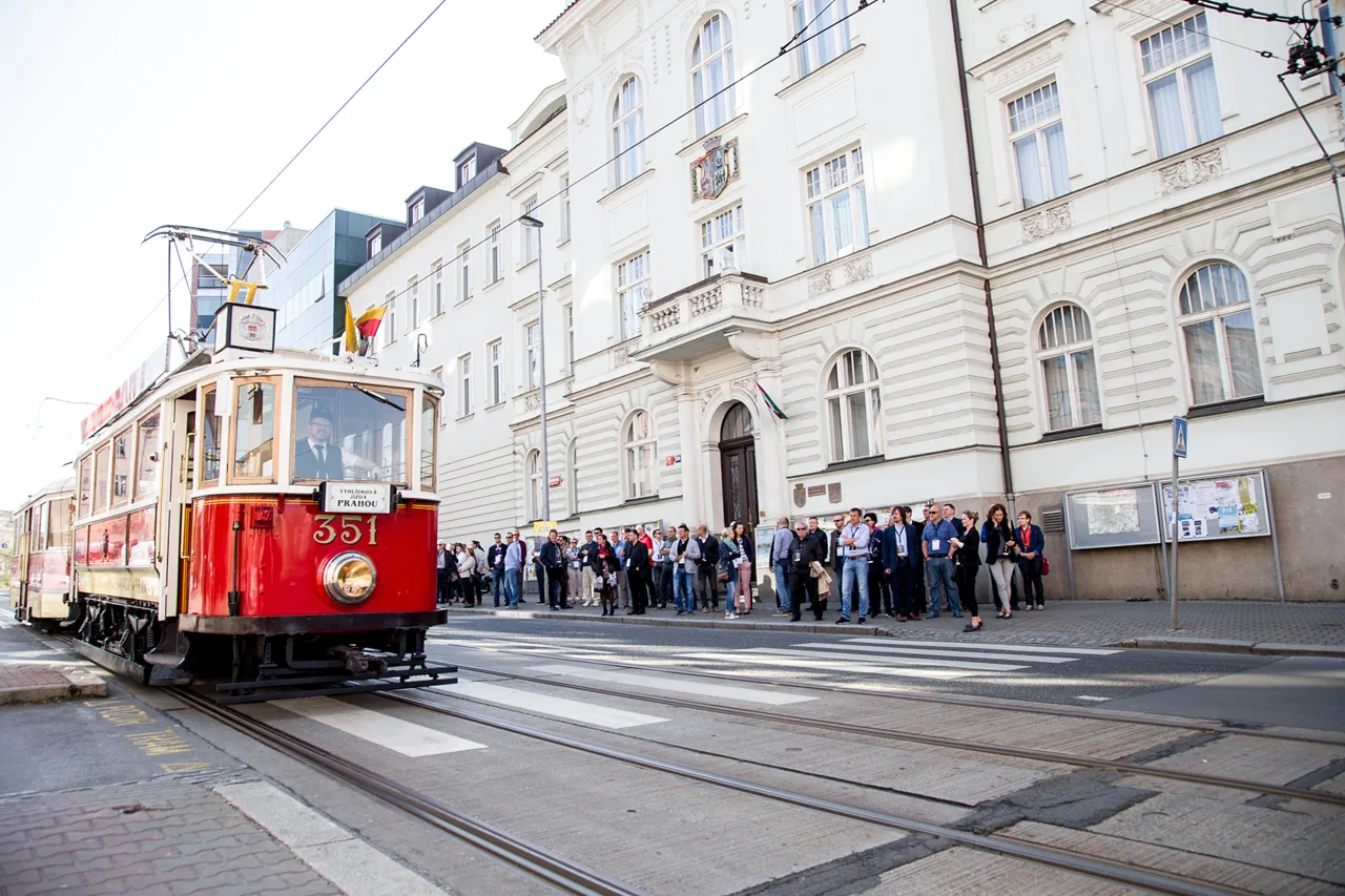 Historická červená tramvaj před městskými domy